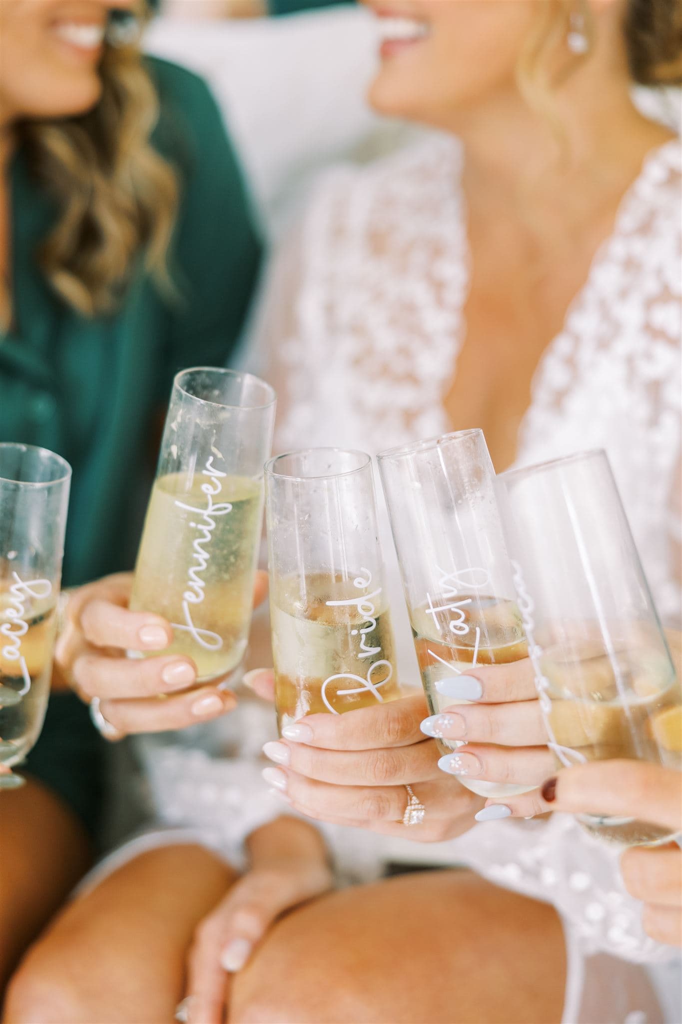 Bride and bridesmaids champagne toast with personalized glasses
