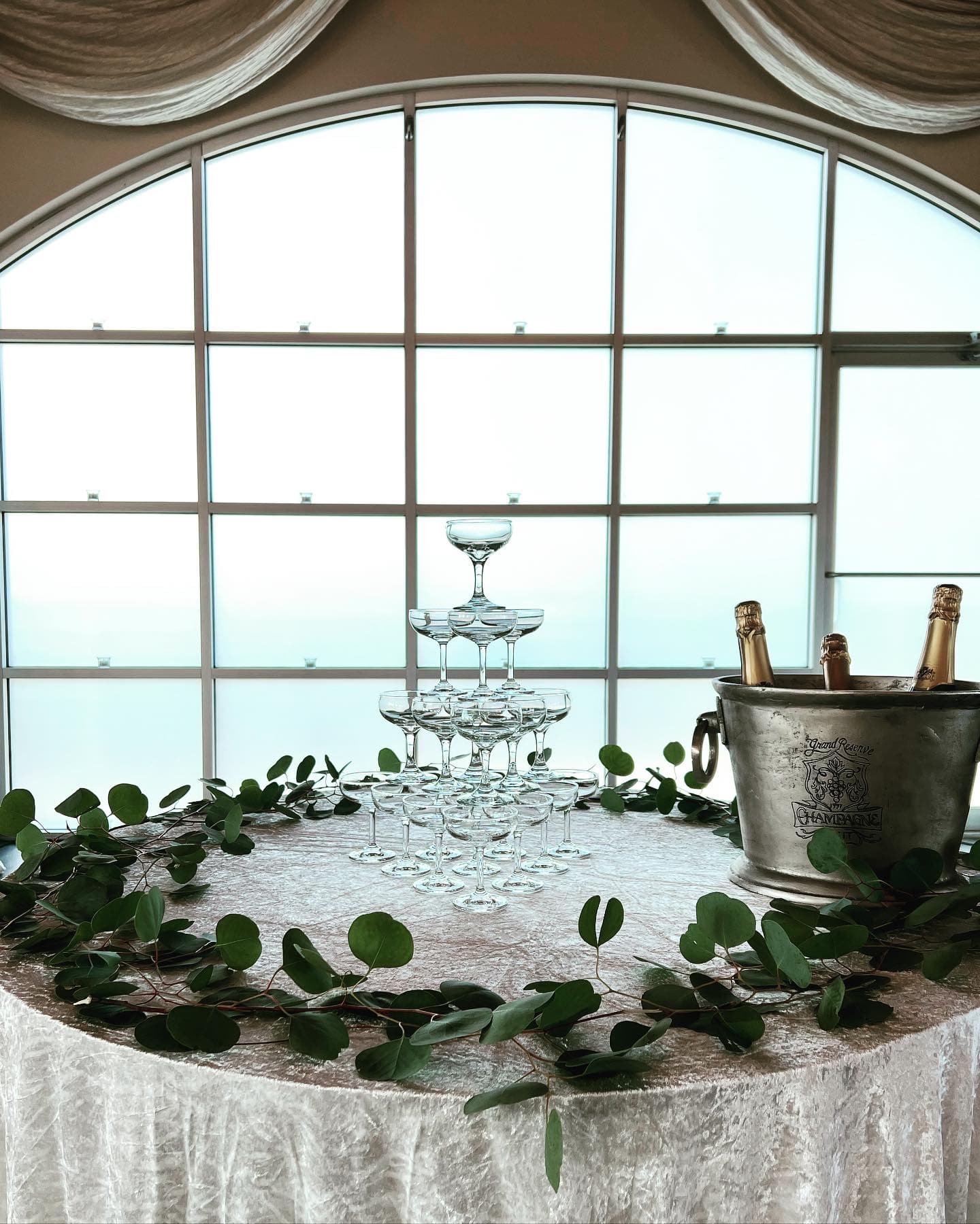 Elegant champagne tower with eucalyptus garland